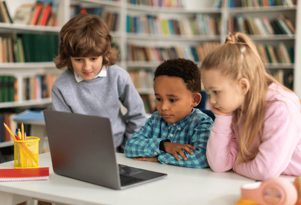 Children using a 1:2:1 device given to a student to watch a video in a classroom.